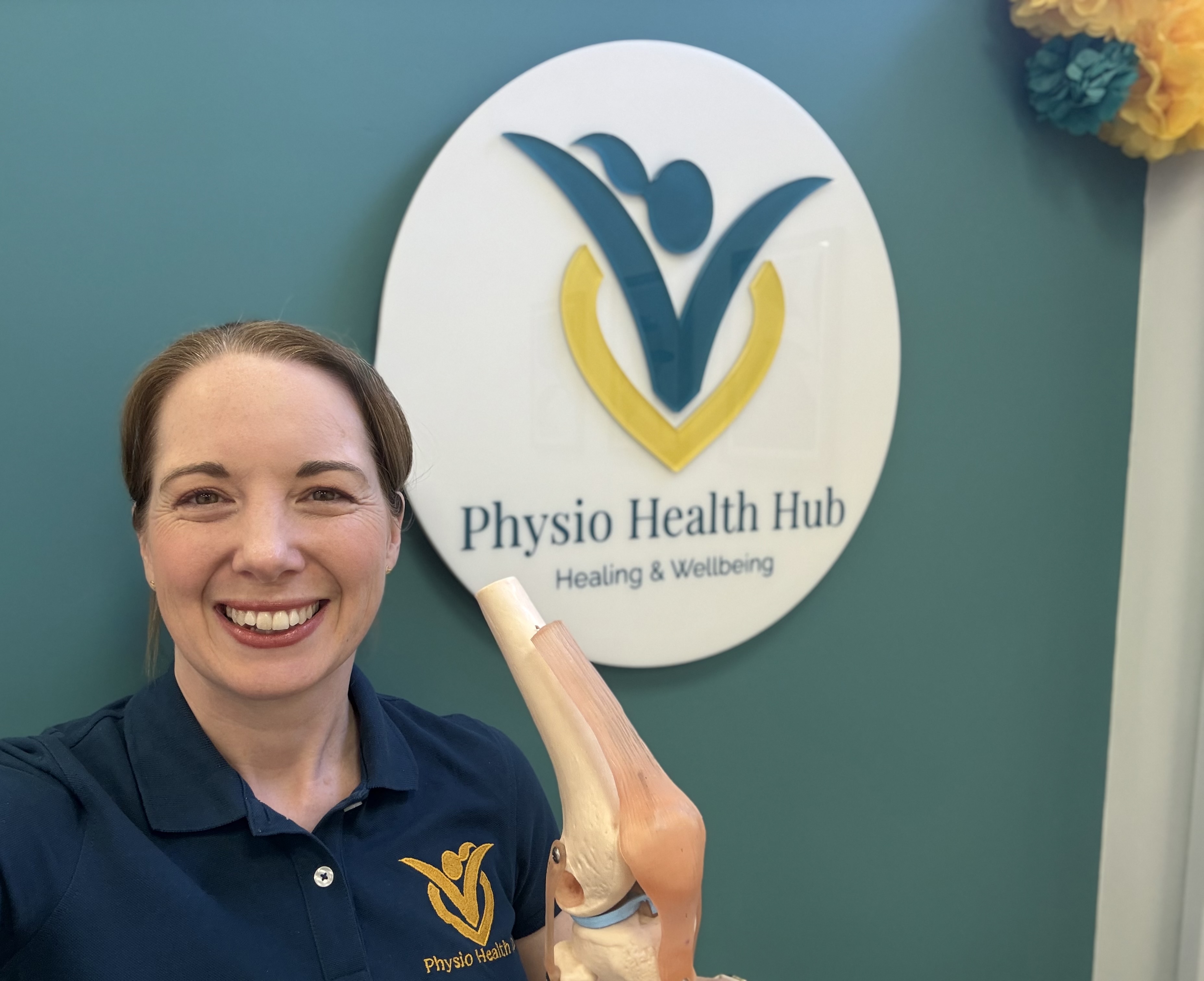 Vicky Sharpe beside the Physio Health Hub sign at the Manor Farm clinic